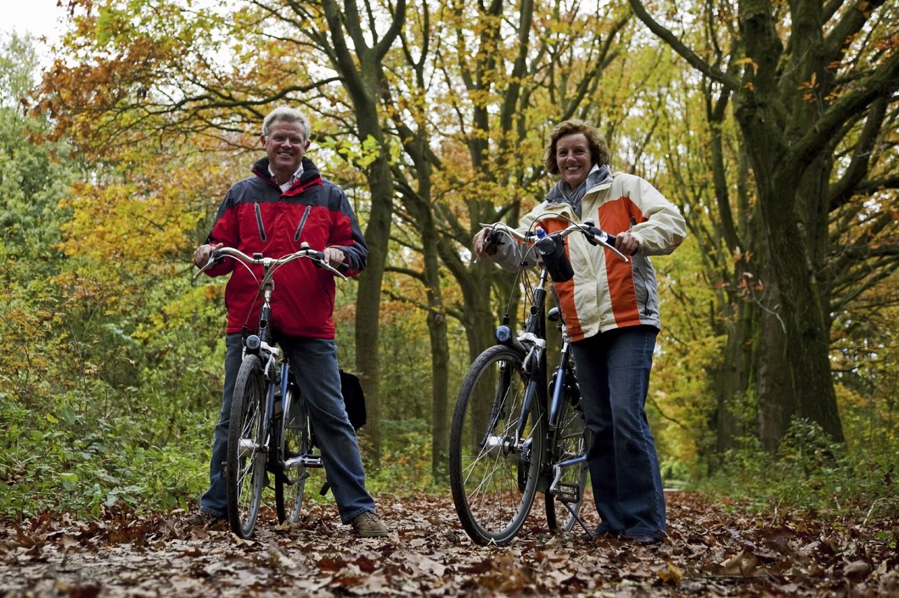 Małżeństwo jadące rowerem po lesie