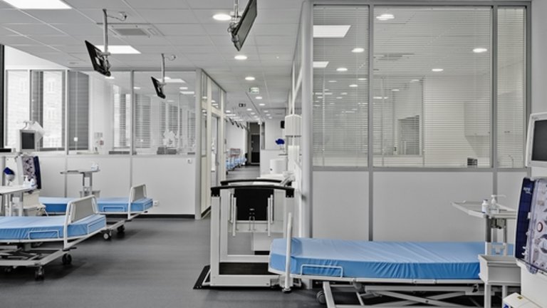 Widok wnętrza stacji dializ z kilkoma pustymi łóżkami