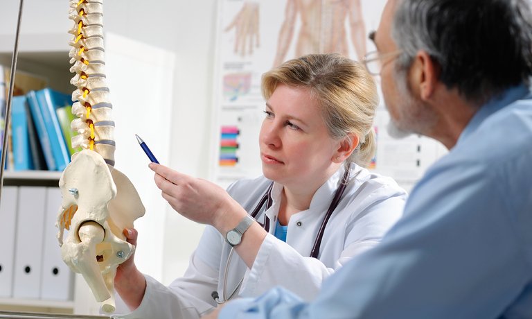 Lekarz wyjaśniający pacjentowi możliwe powikłania wynikające z metabolicznej choroby kości w PChN